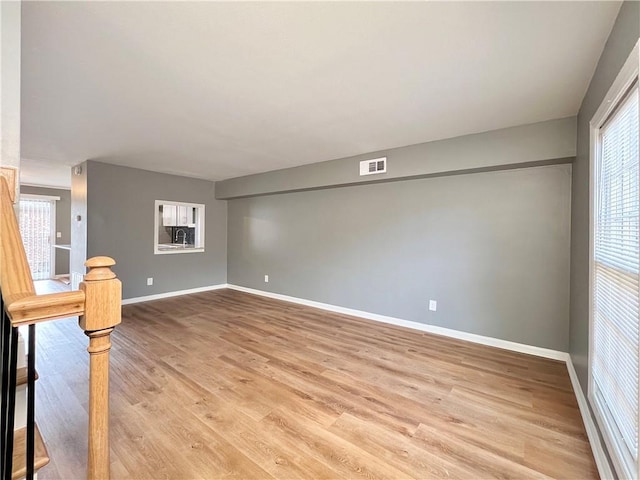 spare room with light wood-style flooring, baseboards, and visible vents