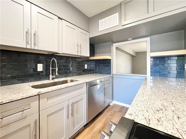 kitchen featuring visible vents, open shelves, a sink, stainless steel dishwasher, and tasteful backsplash