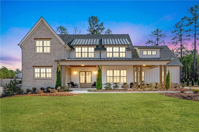 39 Telfair Ct, Acworth, GA 30101 - back of house at dusk featuring french doors, board and batten siding, a standing seam roof, a lawn, and brick siding