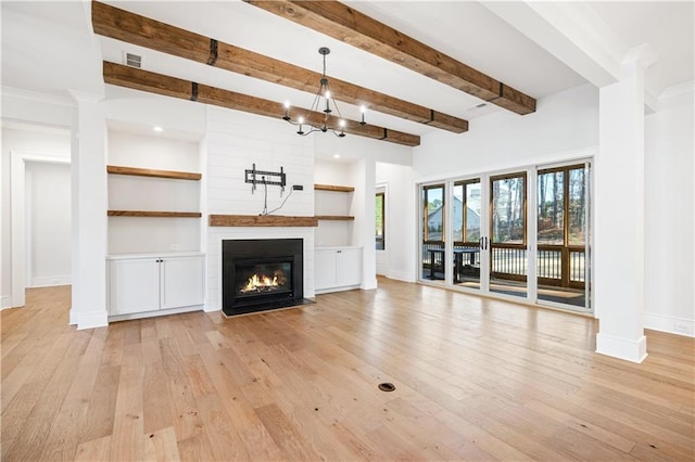 unfurnished living room with light wood finished floors, baseboards, a large fireplace, and beam ceiling