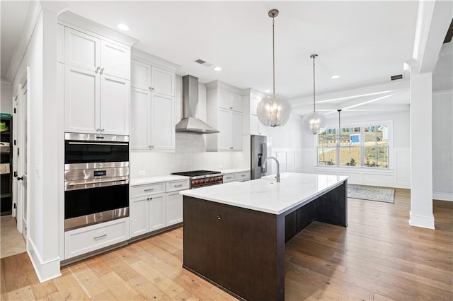 39 Telfair Ct, Acworth, GA 30101 - kitchen with wall chimney exhaust hood, stainless steel appliances, light wood-type flooring, light countertops, and a wainscoted wall