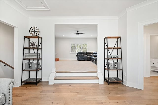 interior space with ceiling fan, crown molding, baseboards, and wood finished floors