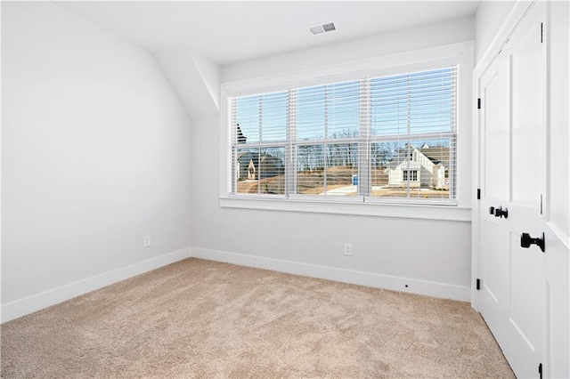 unfurnished room with light carpet, plenty of natural light, visible vents, and baseboards