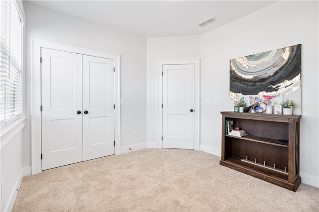 bedroom featuring baseboards, carpet, visible vents, and a closet