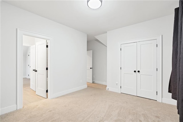 unfurnished bedroom featuring a closet, baseboards, and carpet flooring