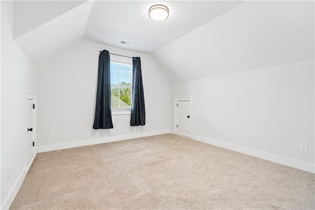 additional living space with carpet floors, lofted ceiling, visible vents, and baseboards