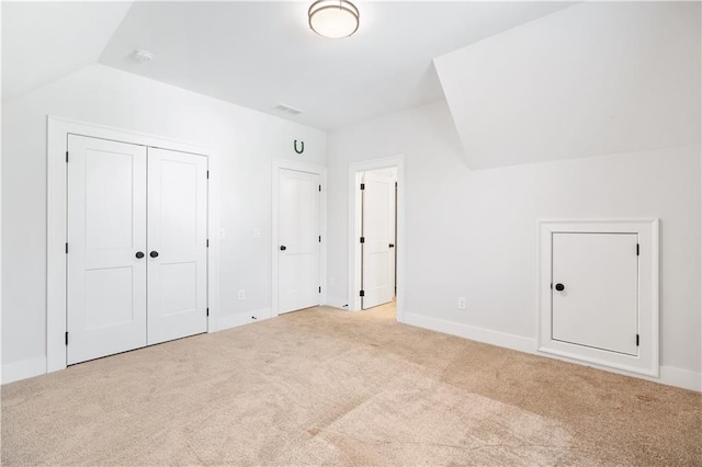 unfurnished bedroom with lofted ceiling, carpet, and baseboards