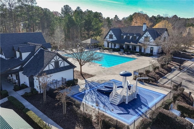 pool with a patio and fence