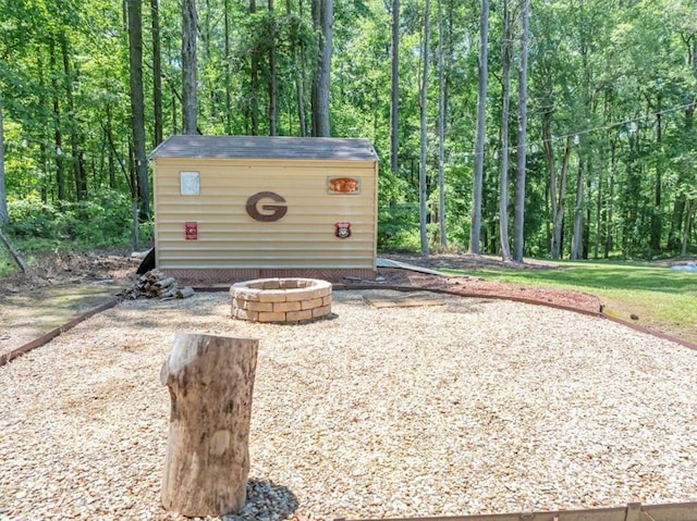 586 Old Bushmill Rd, Bremen, GA 30110 - view of patio featuring an outdoor fire pit, a view of trees, and an outdoor structure