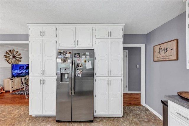 586 Old Bushmill Rd, Bremen, GA 30110 - kitchen featuring stainless steel refrigerator with ice dispenser, white cabinets, baseboards, and a textured ceiling