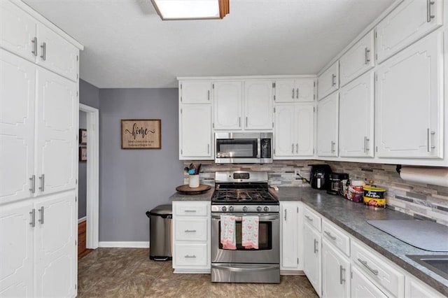 586 Old Bushmill Rd, Bremen, GA 30110 - kitchen featuring stainless steel appliances, dark countertops, backsplash, white cabinets, and baseboards