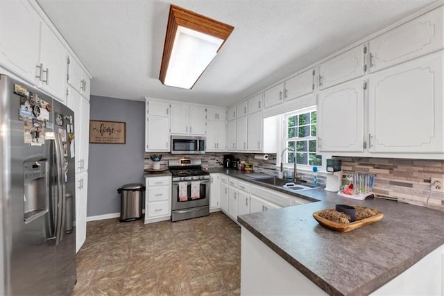 586 Old Bushmill Rd, Bremen, GA 30110 - kitchen featuring stainless steel appliances, dark countertops, a sink, and white cabinetry