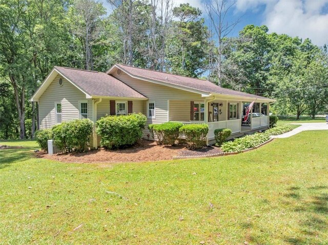 586 Old Bushmill Rd, Bremen, GA 30110 - view of side of property featuring covered porch, a yard, a shingled roof, and view of wooded area