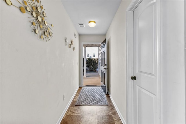 hallway featuring visible vents and baseboards