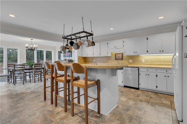 kitchen with white cabinetry, decorative light fixtures, white refrigerator, dishwasher, and decorative backsplash