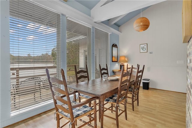 dining room featuring vaulted ceiling and light hardwood / wood-style flooring