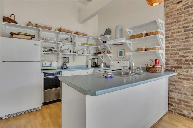 kitchen featuring white cabinetry, sink, white appliances, kitchen peninsula, and light wood-type flooring