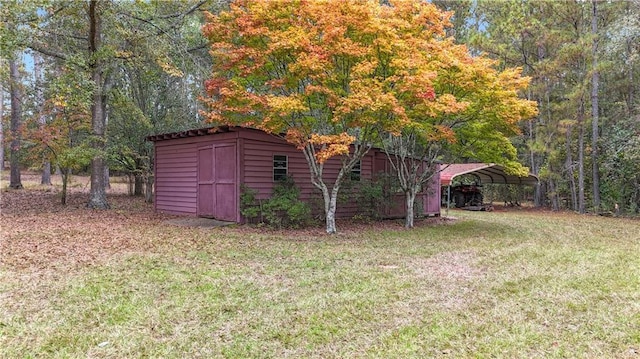 view of outdoor structure with a carport and a lawn