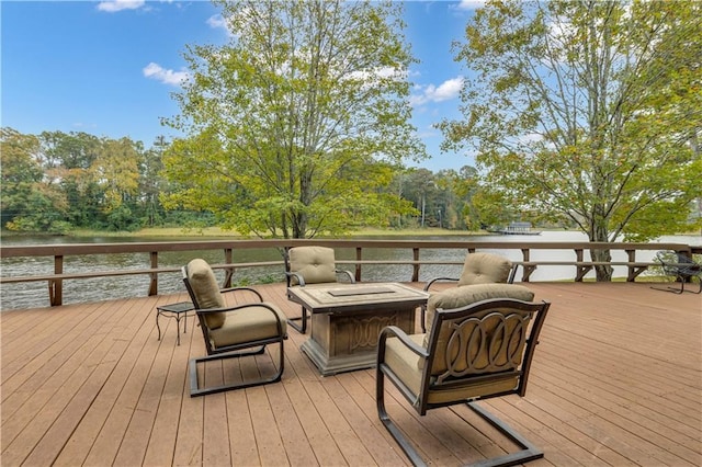 wooden terrace featuring a water view and a fire pit