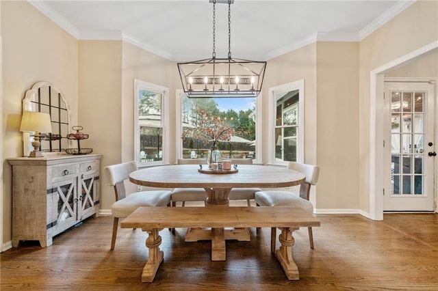 dining area with crown molding, a notable chandelier, wood finished floors, and baseboards