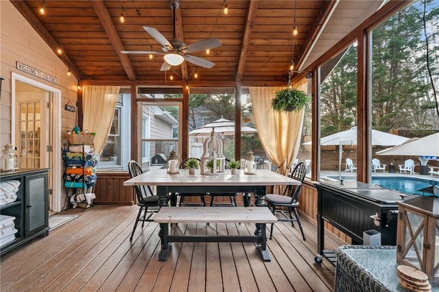 sunroom featuring lofted ceiling with beams, wood ceiling, a wealth of natural light, and ceiling fan