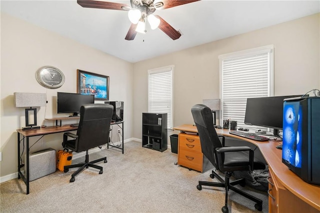 office area featuring a ceiling fan, plenty of natural light, light colored carpet, and baseboards