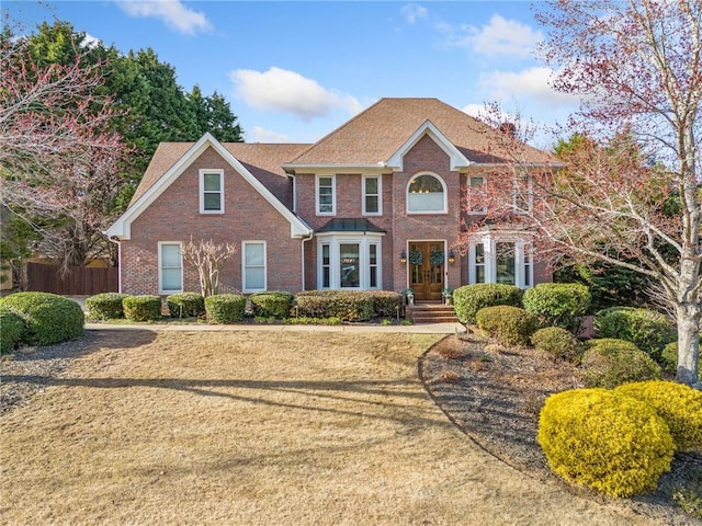 colonial house with fence and brick siding