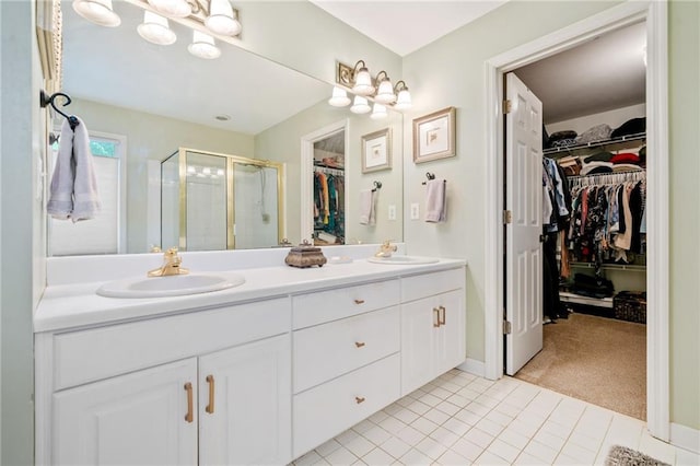 full bathroom featuring double vanity, tile patterned flooring, a shower stall, and a sink