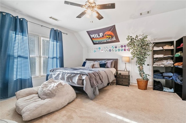 carpeted bedroom with visible vents, ceiling fan, and vaulted ceiling