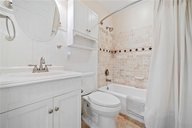 bathroom featuring toilet, shower / bath combo with shower curtain, and vanity