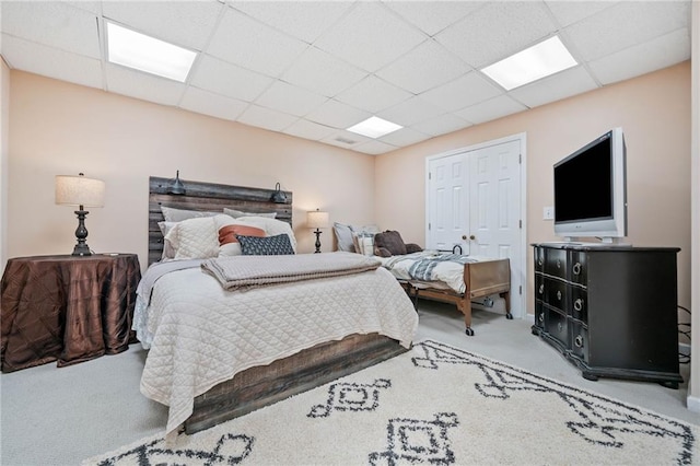 bedroom featuring visible vents, carpet, a closet, and a drop ceiling