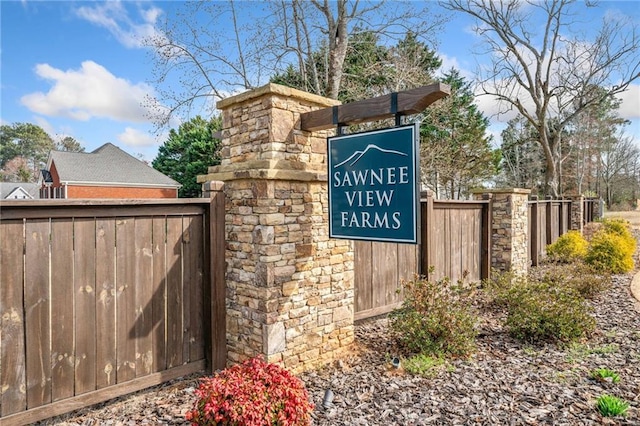 community / neighborhood sign featuring fence