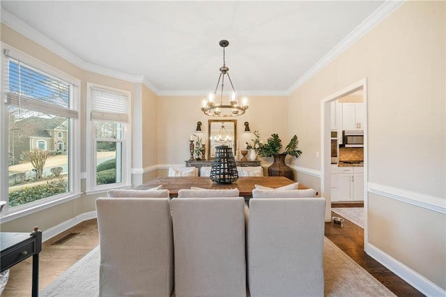 dining room featuring an inviting chandelier, visible vents, dark wood-style flooring, and ornamental molding