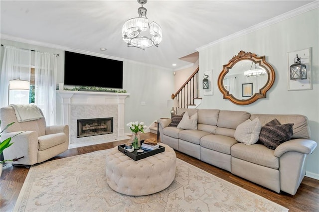 living area with wood finished floors, ornamental molding, and a fireplace