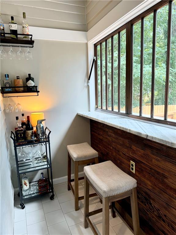 1670 Rogers Ave SW, Atlanta, GA 30310 - living area featuring baseboards, a dry bar, and light tile patterned flooring