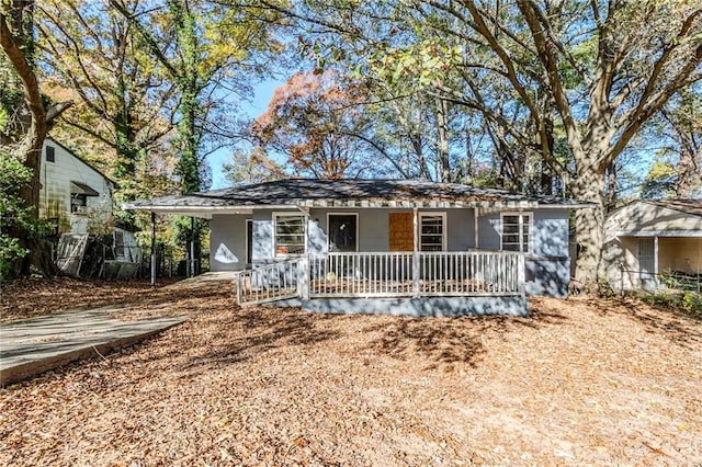 ranch-style home featuring a porch and a carport