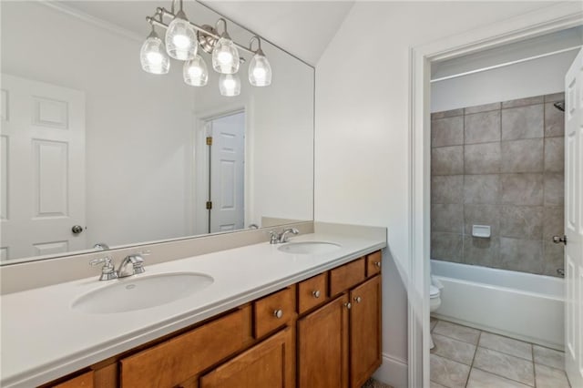 full bathroom featuring tiled shower / bath, tile patterned floors, vanity, toilet, and ornamental molding