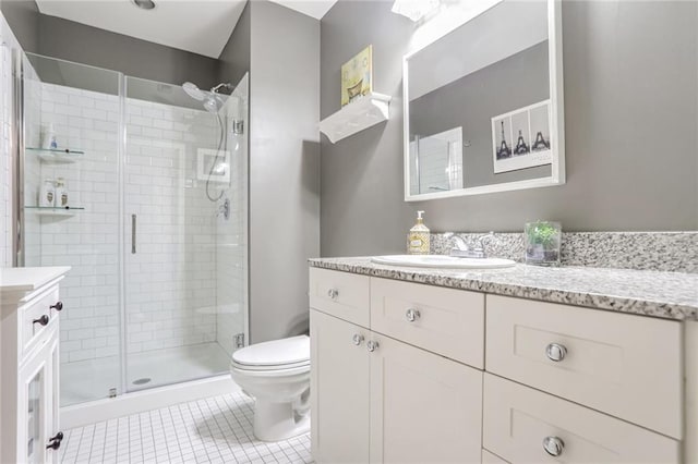 bathroom featuring toilet, tile patterned floors, a stall shower, and vanity