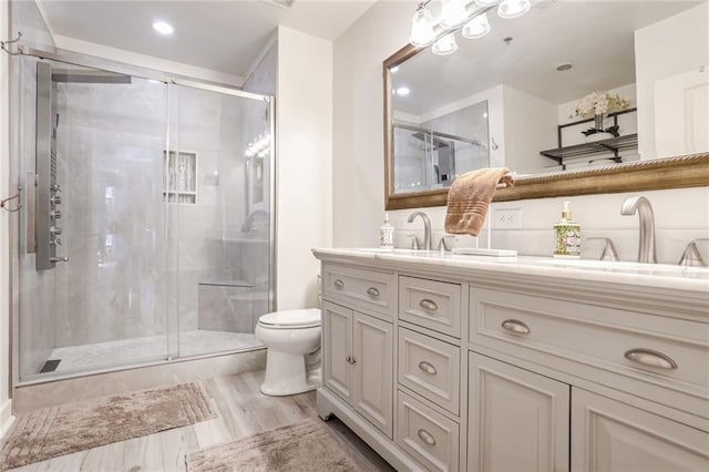 full bath featuring double vanity, a stall shower, toilet, and a sink