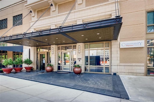 view of exterior entry featuring brick siding