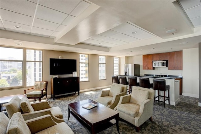 565 Peachtree St NE Unit 1303, Atlanta, GA 30308 - living room with a drop ceiling, baseboards, dark carpet, and a tray ceiling