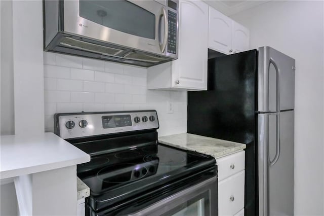 kitchen featuring backsplash, white cabinets, and stainless steel appliances