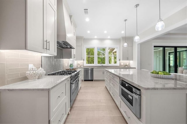 5990 Watermark Cv, Gainesville, GA 30506 - kitchen with appliances with stainless steel finishes, wall chimney exhaust hood, white cabinetry, decorative backsplash, and recessed lighting