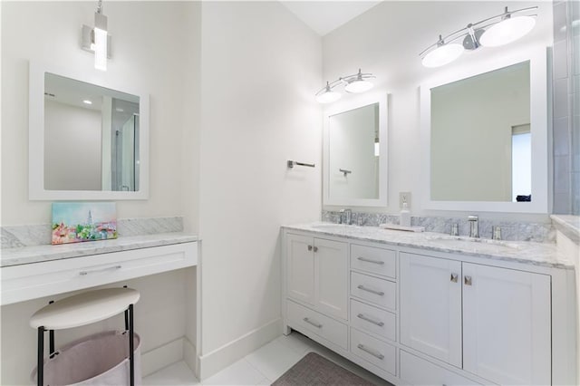 full bath with double vanity, a sink, tile patterned floors, and baseboards