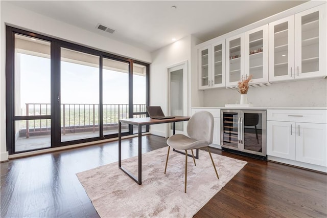 home office featuring visible vents, dark wood-style flooring, and beverage cooler