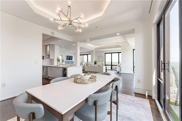 dining room with dark wood-style floors, a notable chandelier, and a raised ceiling