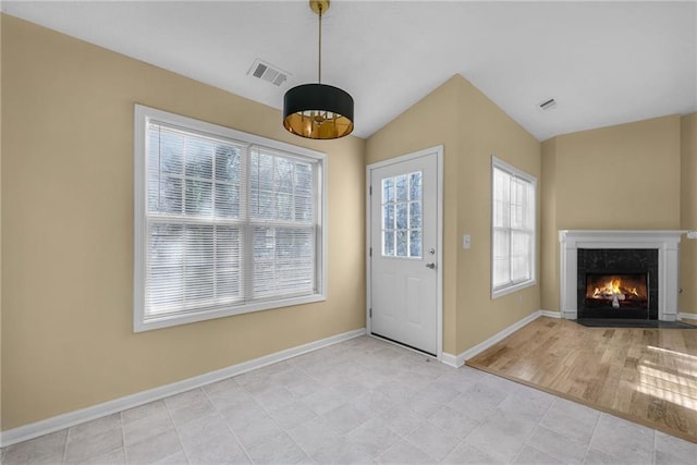 entrance foyer with a premium fireplace, a wealth of natural light, and vaulted ceiling