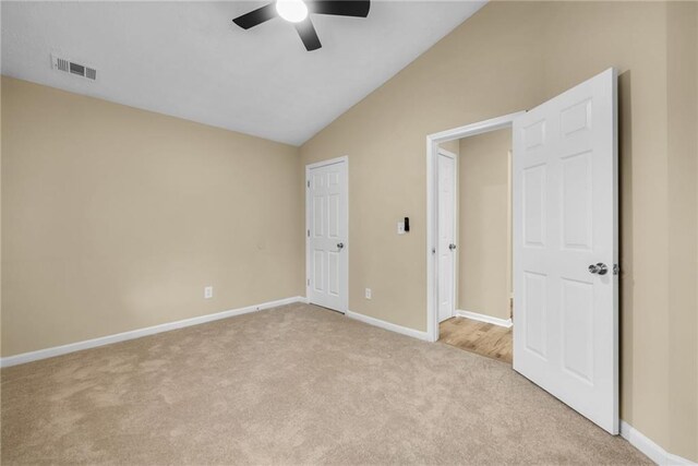 unfurnished bedroom with light carpet, vaulted ceiling, and ceiling fan