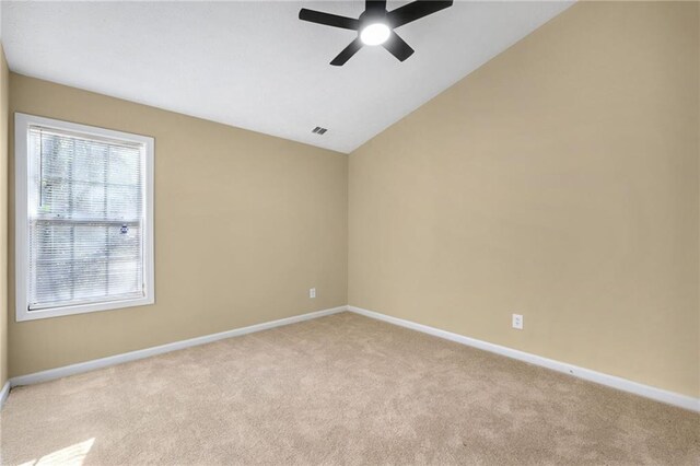 empty room with light carpet, vaulted ceiling, and ceiling fan