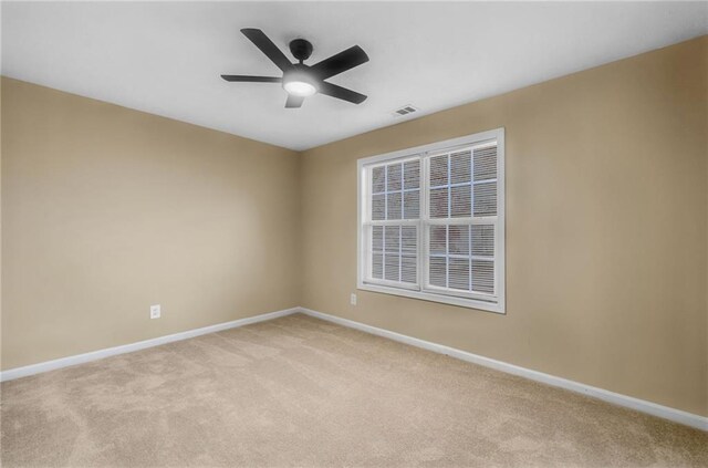 spare room featuring light colored carpet and ceiling fan